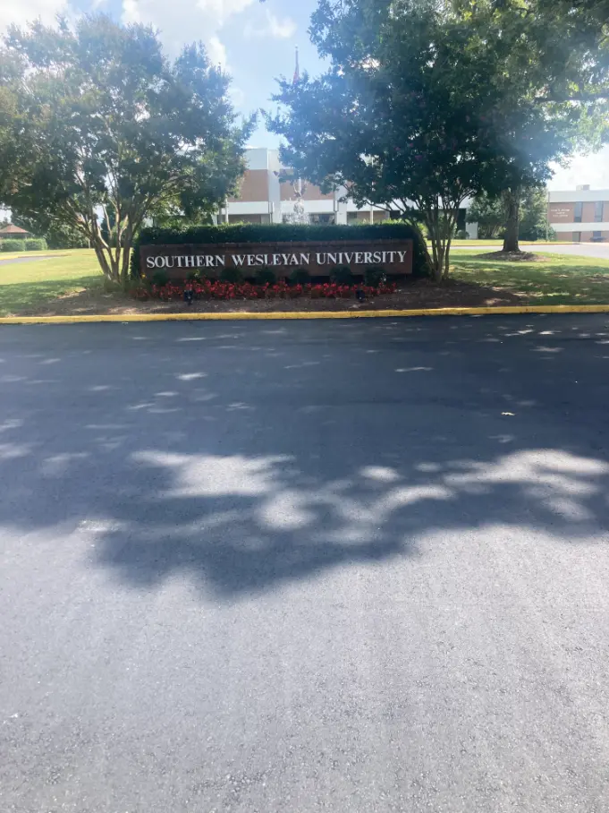 Freshly paved asphalt in front of a sign for Southern Wesleyan University